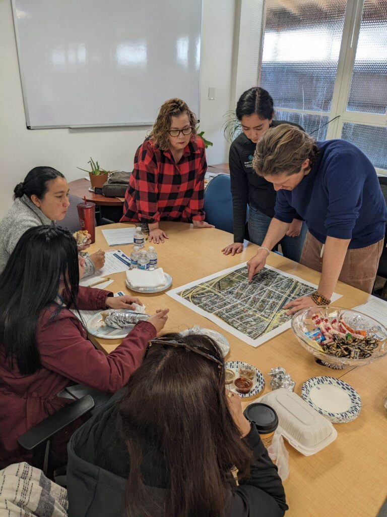People looking at a map on a table in a conference room