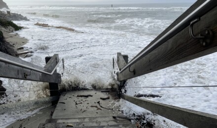 Ocean water at the bottom of a wooden staircase at a beach